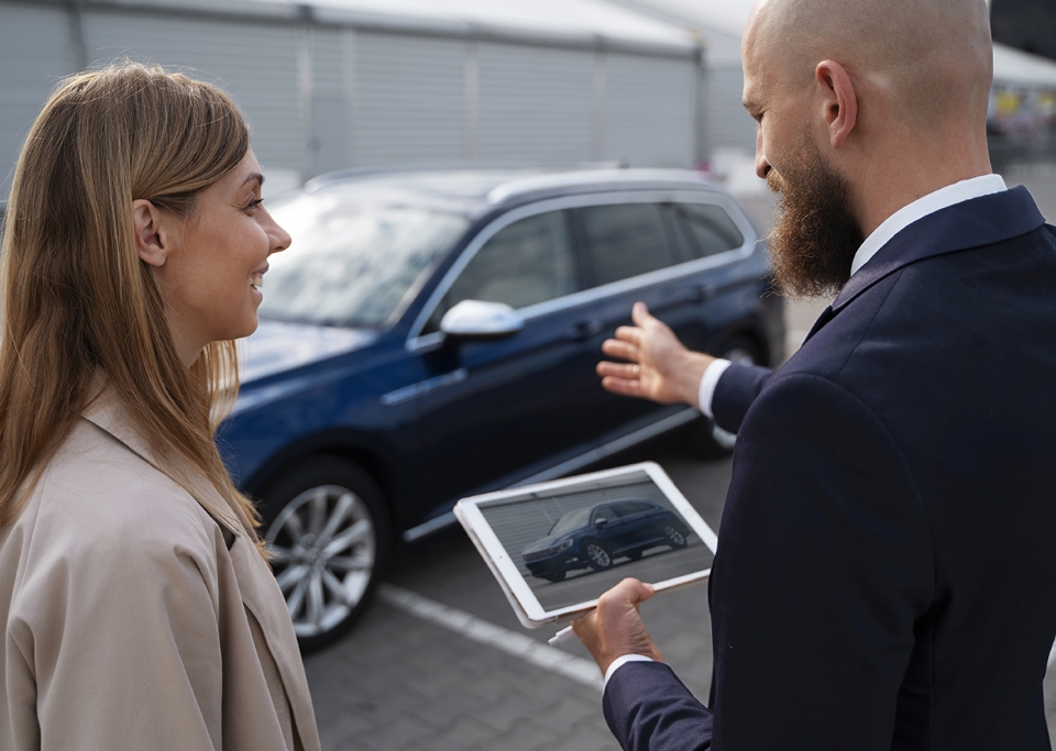 Homme montrant une voiture à une femme